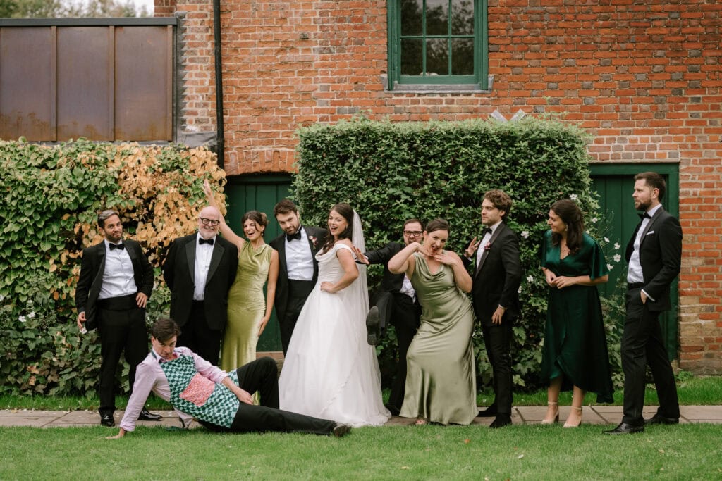 Group of people posing in wedding attire outside.