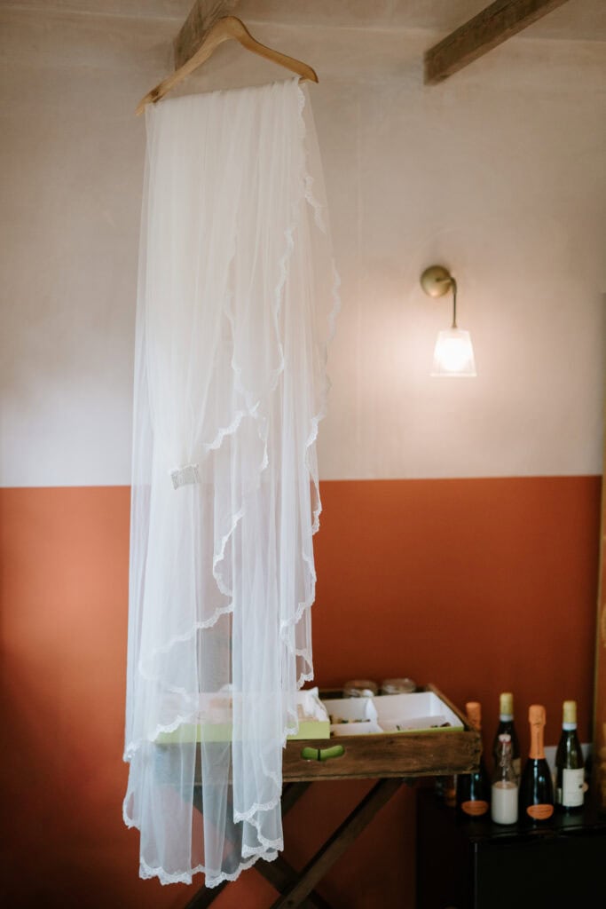 Hanging white wedding veil, rustic room setting.