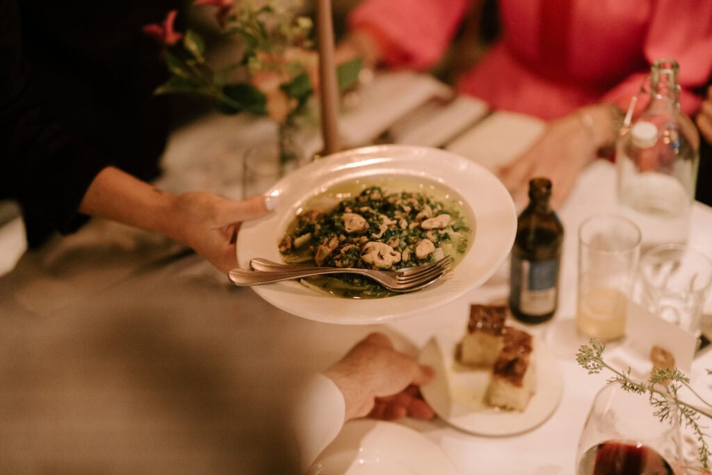 Person serving pasta dish at updown farmhouse wedding breakfast