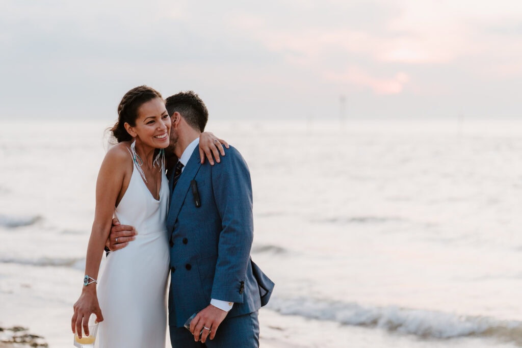 Couple embracing on margate beach at sunset.