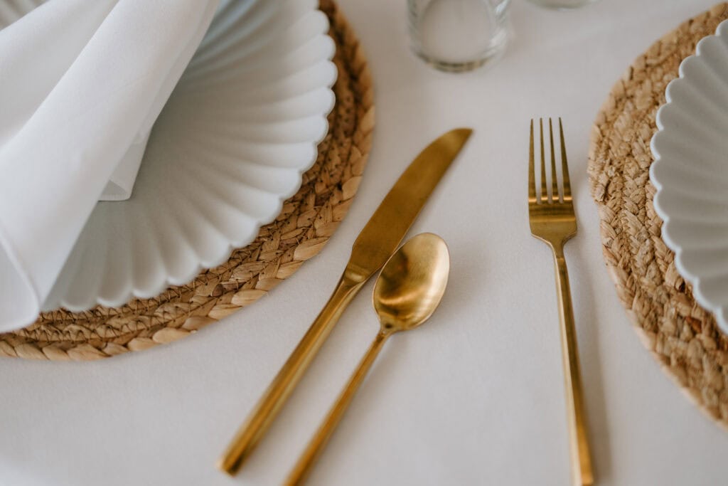 Elegant dining table setting with gold cutlery.