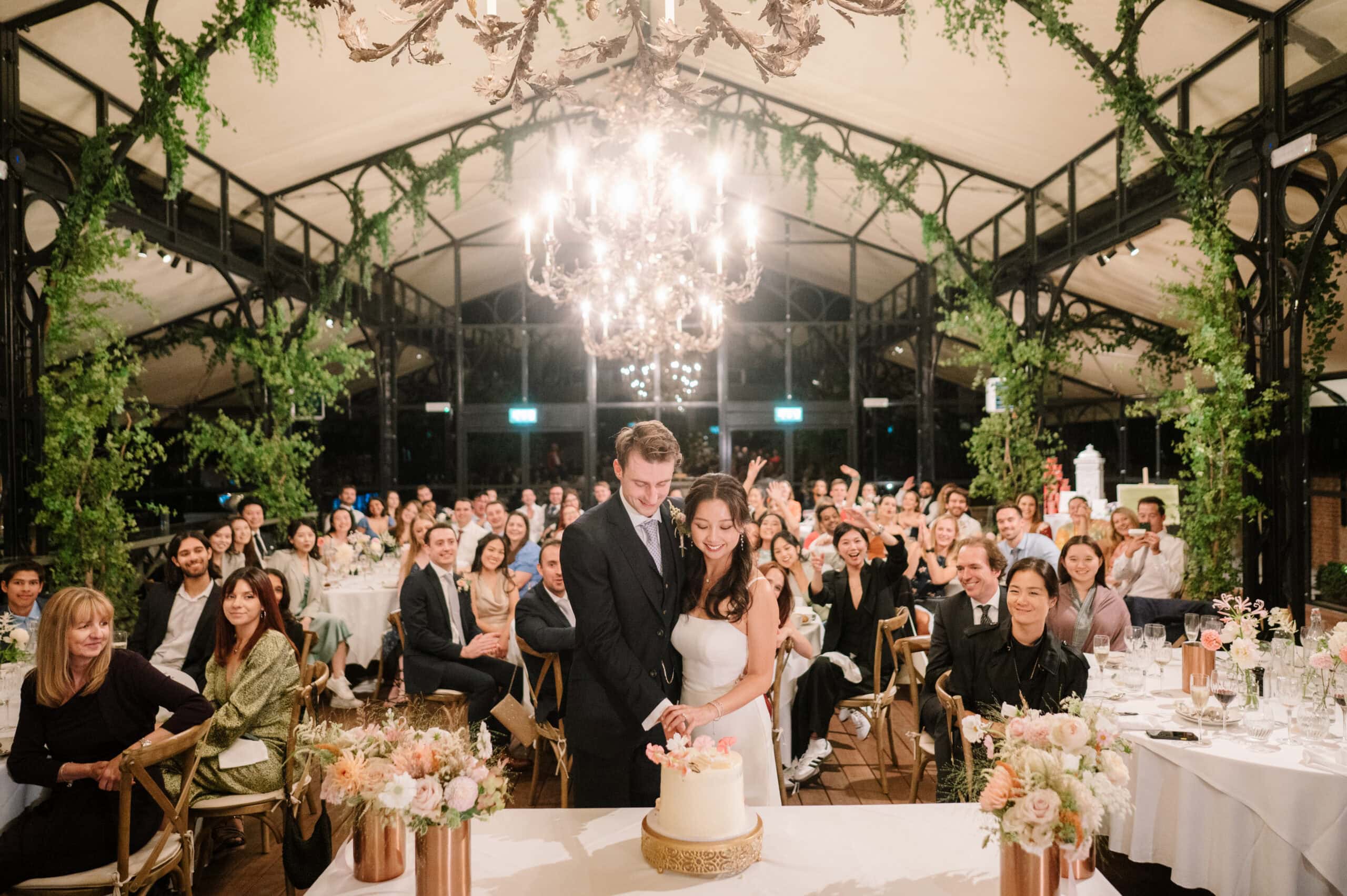 Bride and groom cutting cake at wedding reception