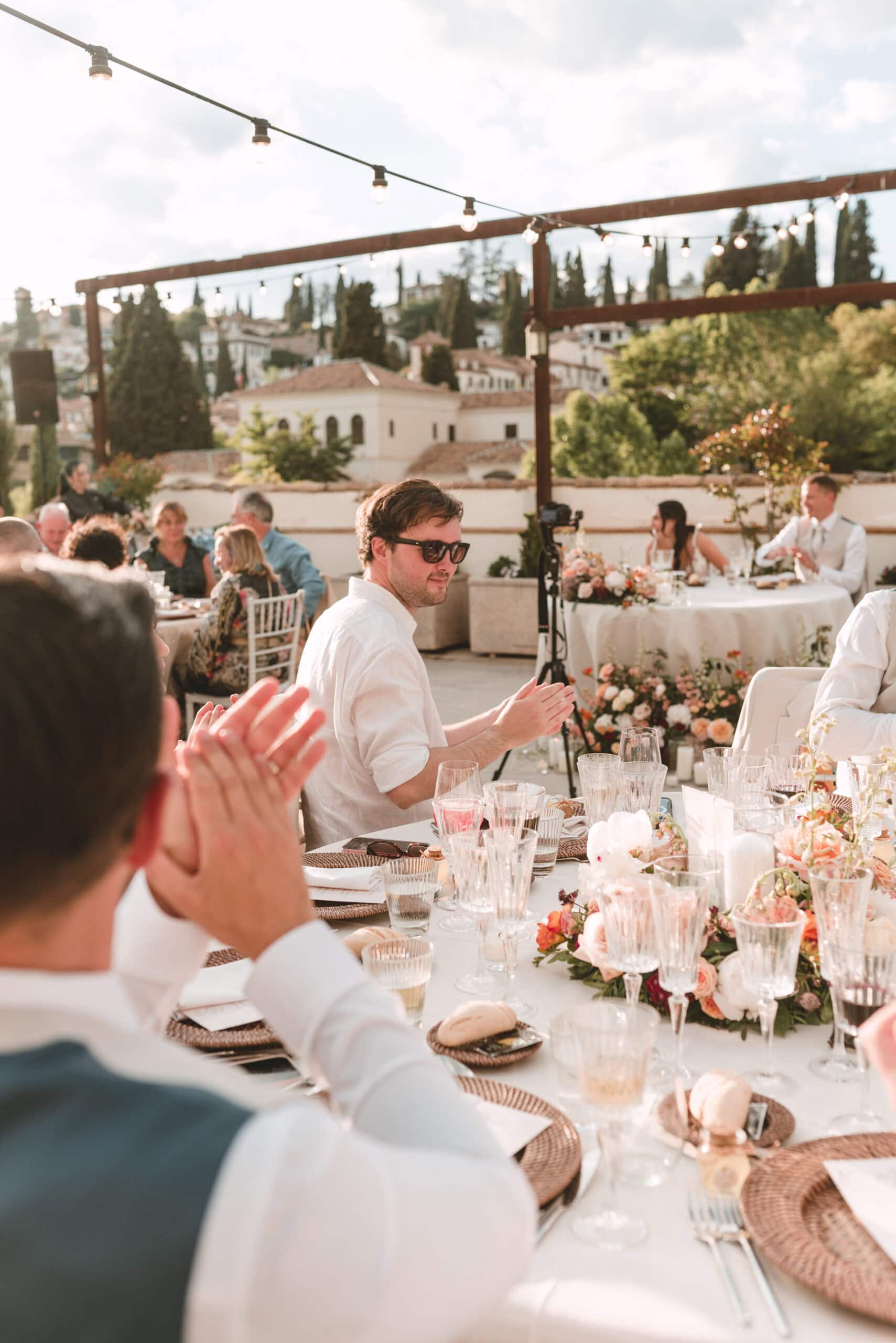 Guests applauding at outdoor wedding reception dinner