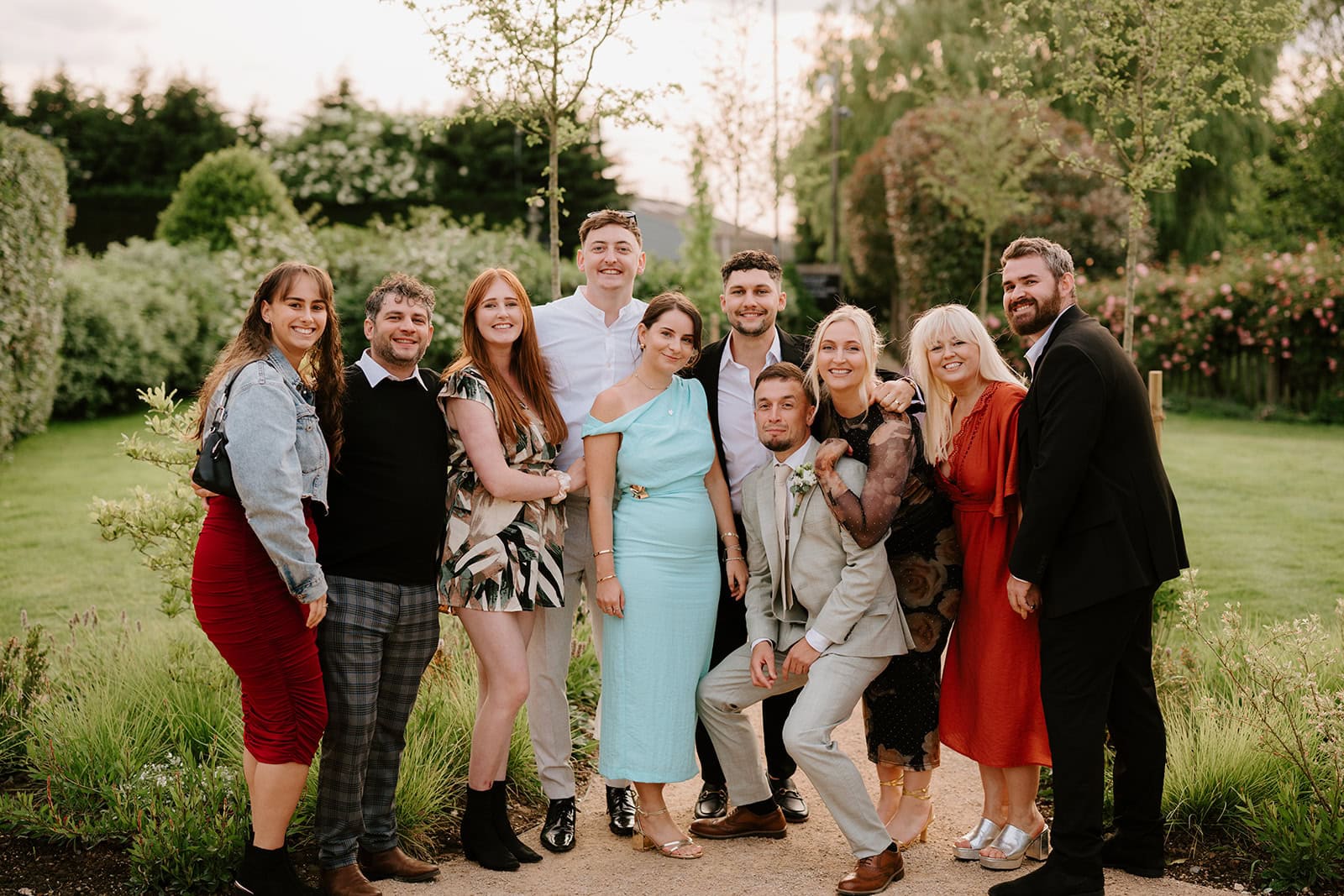 Group of friends posing at outdoor garden wedding