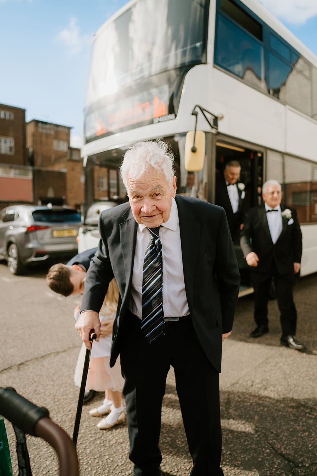 Elderly man with cane exiting double-decker bus