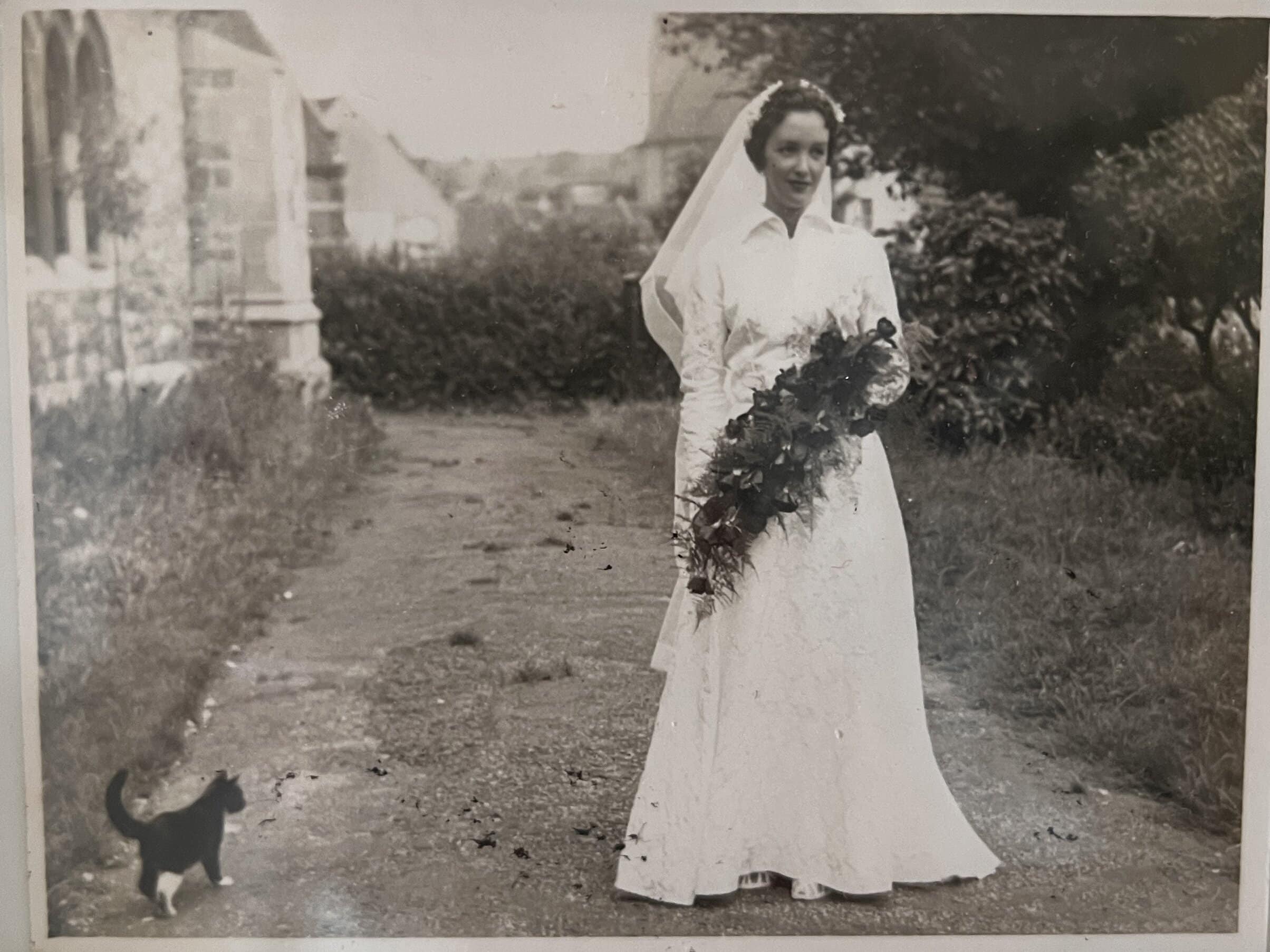 Vintage bride with bouquet and cat outdoors