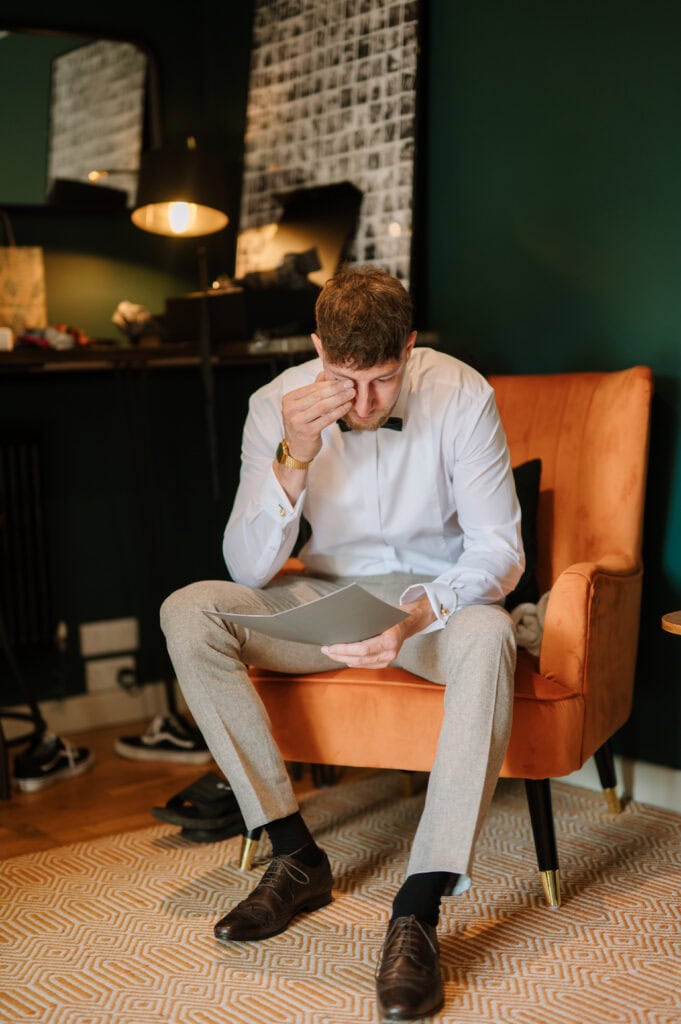 Man in formalwear reading document looking stressed