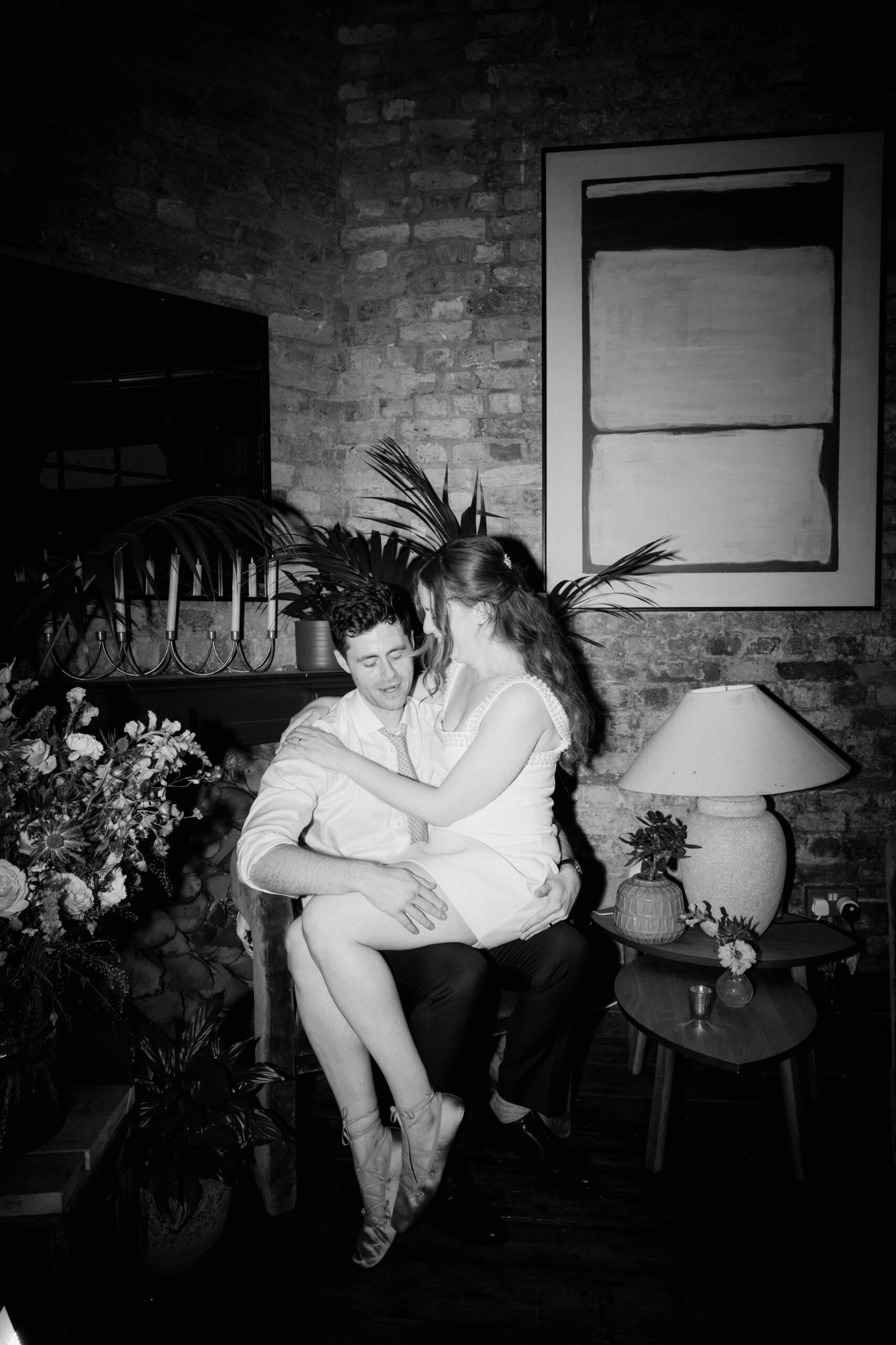 Couple embracing in candlelit brick-walled room