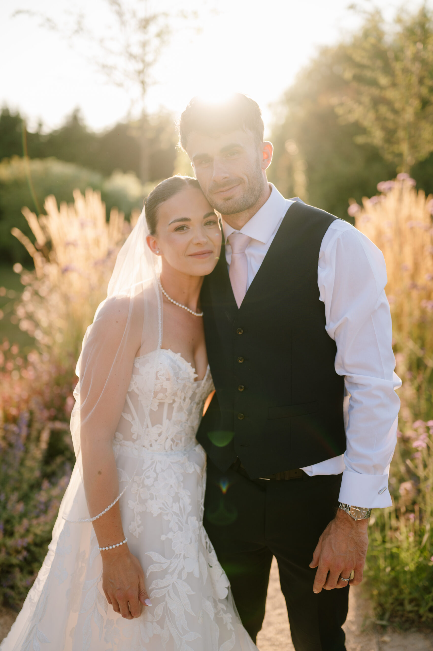 Bride and groom embracing at sunset outdoors in the new gardens at the old kent barn